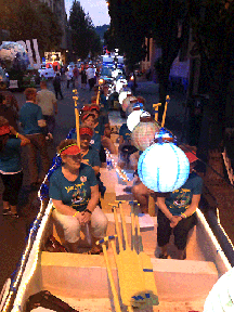 Cultural Programs: View of dragon boat team on the old Traditional-style Dragon Boat Float while lit up at night.